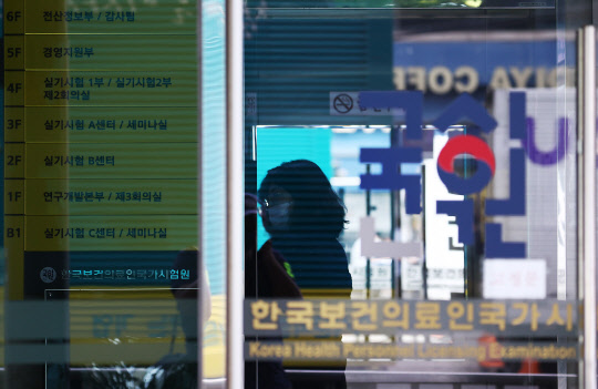 전국 의과대학 본과 4학년생들이 기존의 입장을 바꿔 국가고시 응시 의사를 표시한 24일 자양동에 위치한 한국보건의료인국가시험원(국시원)에 관계자가 출입구를 관리하고 있다.   연합뉴스